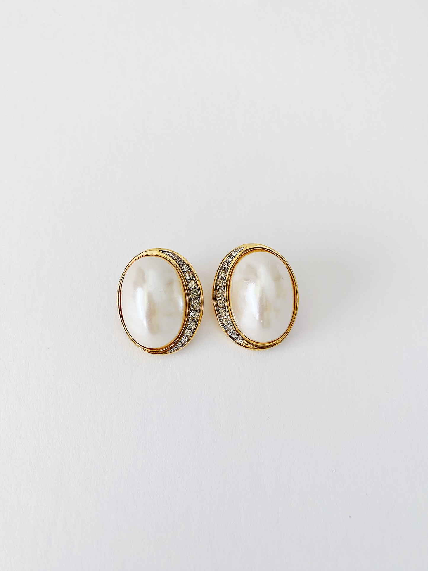 Vintage 1980s Richelieu clip-on earrings with faux pearl center, gold-plated oval design, crescent pavé rhinestone accents, lightweight classic earrings