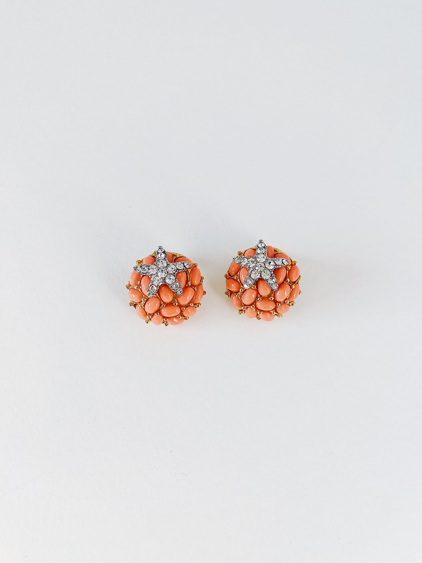 Vintage 1990s KJL Kenneth Jay Lane starfish earrings, faux coral cluster with clear rhinestone pave, gold-tone clip-on statement earrings.