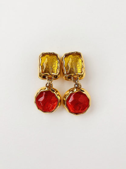 Vintage 1980s Essex gold-plated statement earrings with hammered metal texture and faux Gripoix glass cabochons in red and yellow. Clip-on style, mid-weight, bold couture-inspired design.