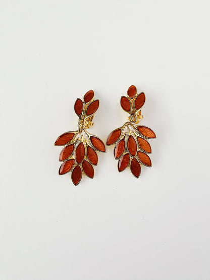 Vintage 1980s Orena Paris gold-plated clip-on earrings with cascading leaf design and rich amber enamel detailing. Lightweight and elegant French jewelry.