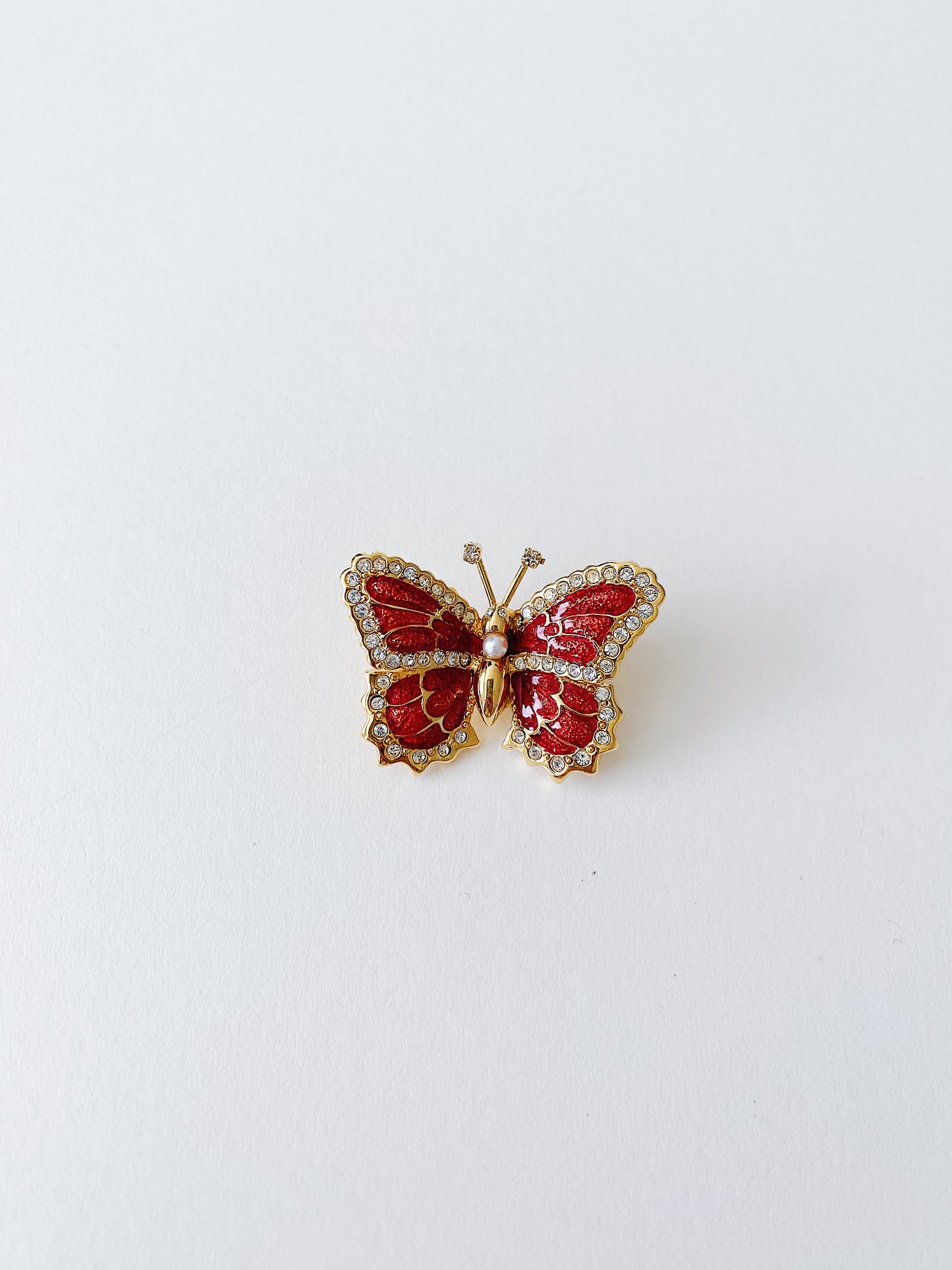 Vintage St. John butterfly brooch with red enamel wings and clear crystal accents, 24k gold plated, 1990s.