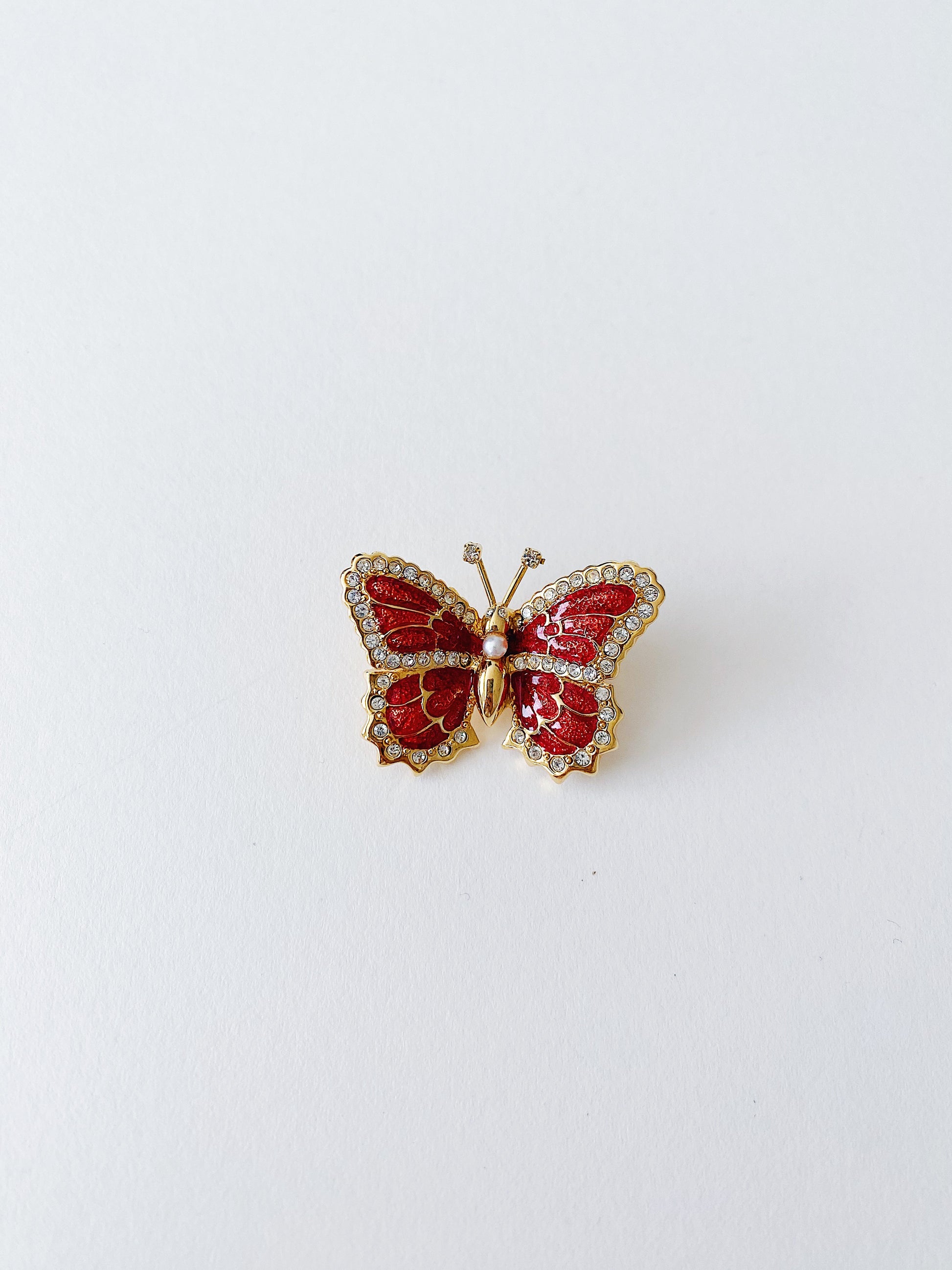 Vintage St. John butterfly brooch with red enamel wings and clear crystal accents, 24k gold plated, 1990s.