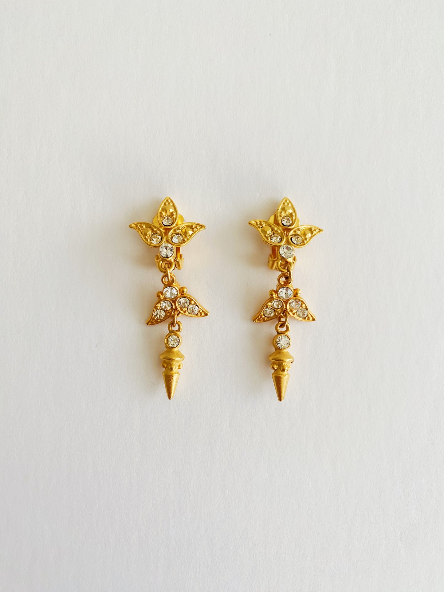 Vintage 1980s brushed gold spike dangle clip-on earrings with clear rhinestone accents, bold statement jewelry.