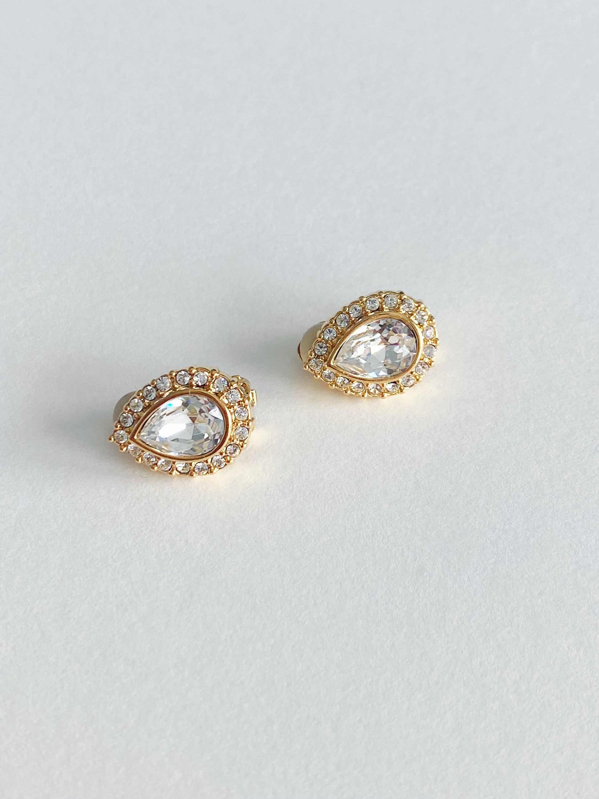Vintage 1990s Swarovski teardrop crystal clip-on earrings with round crystal halo in tone-plated metal setting.